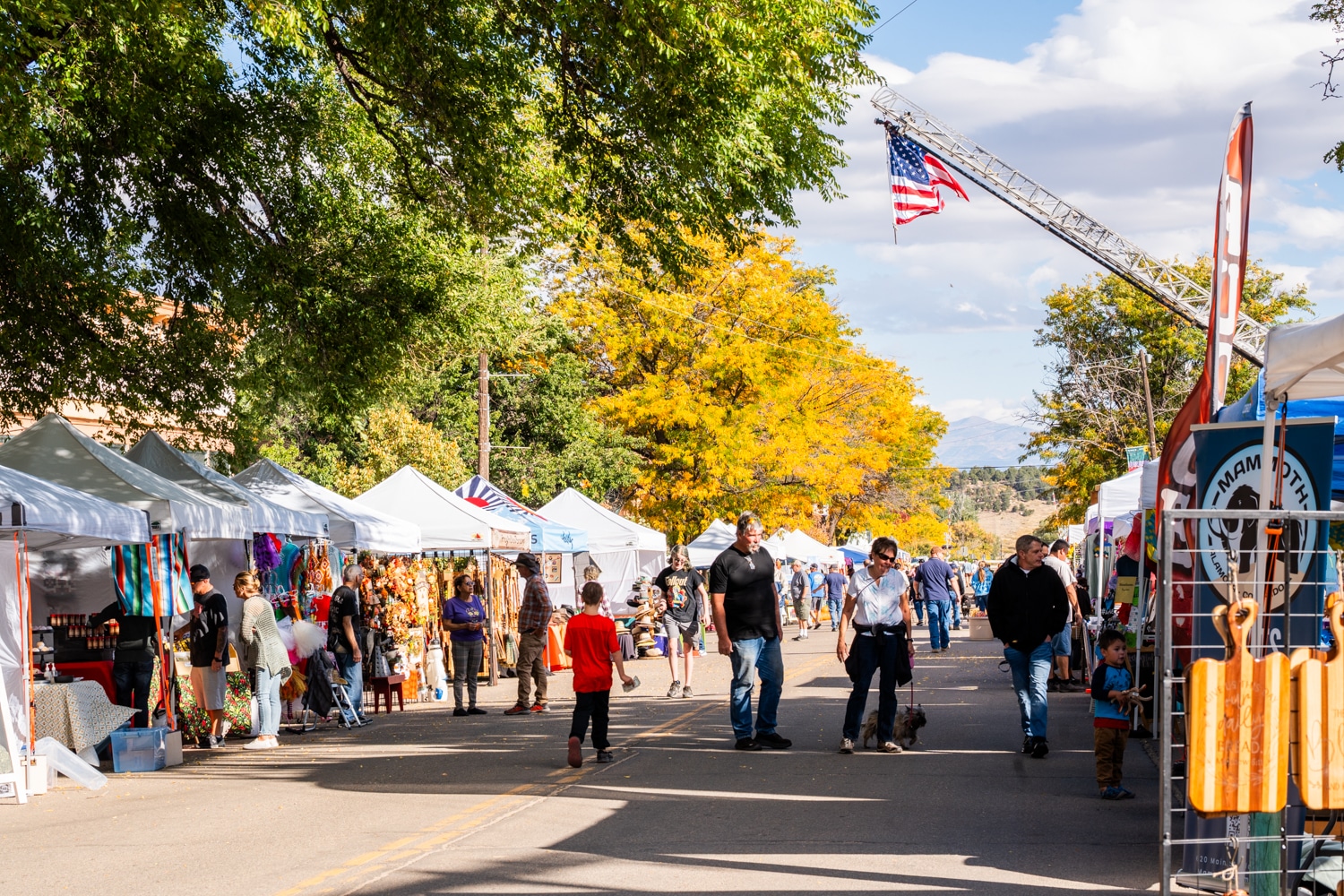 Vendor tents lining Main Street under fall color at a La Veta street festival
